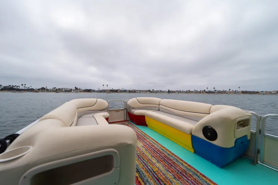 Disco Boat rooftop bow seating in jewel-tone colors with a view across the bay