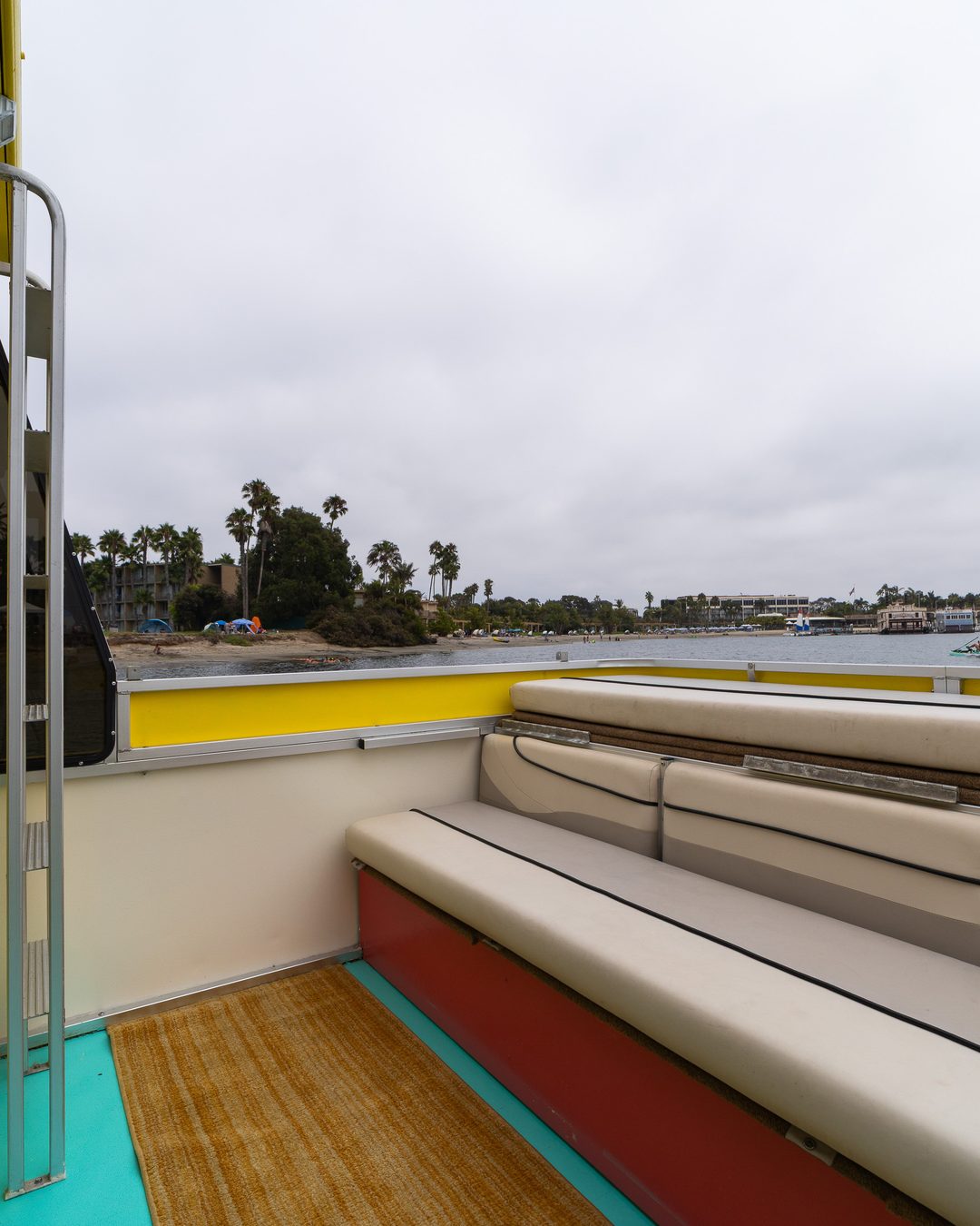 Rooftop deck of the Disco Boat with open-air lounge seating and view across the bay
